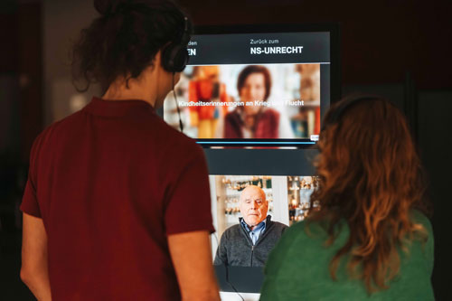 Mobile Multimedia-Ausstellung »Was bleibt?«, 3. Eröffnung in Bremen (Osterholz-Tenever) am 02.12.24, Besucher*innen an kleinen & großen Tablets, Fotoquelle: MOVES gUG